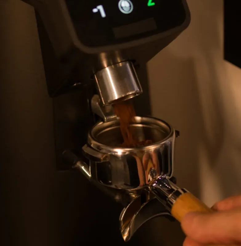 Molino de café dosificando café recién molido en el portafiltros